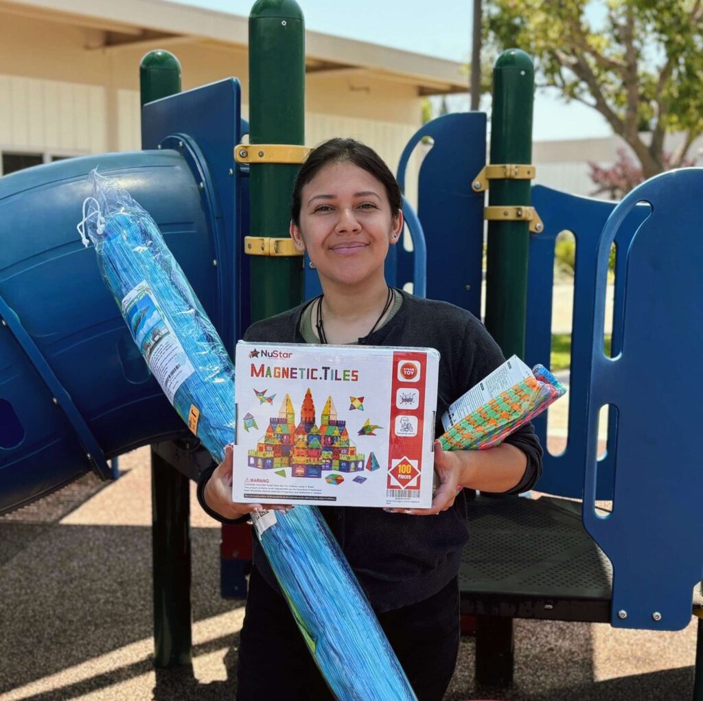 Teacher holding up new supplies for the Adult Day Program.