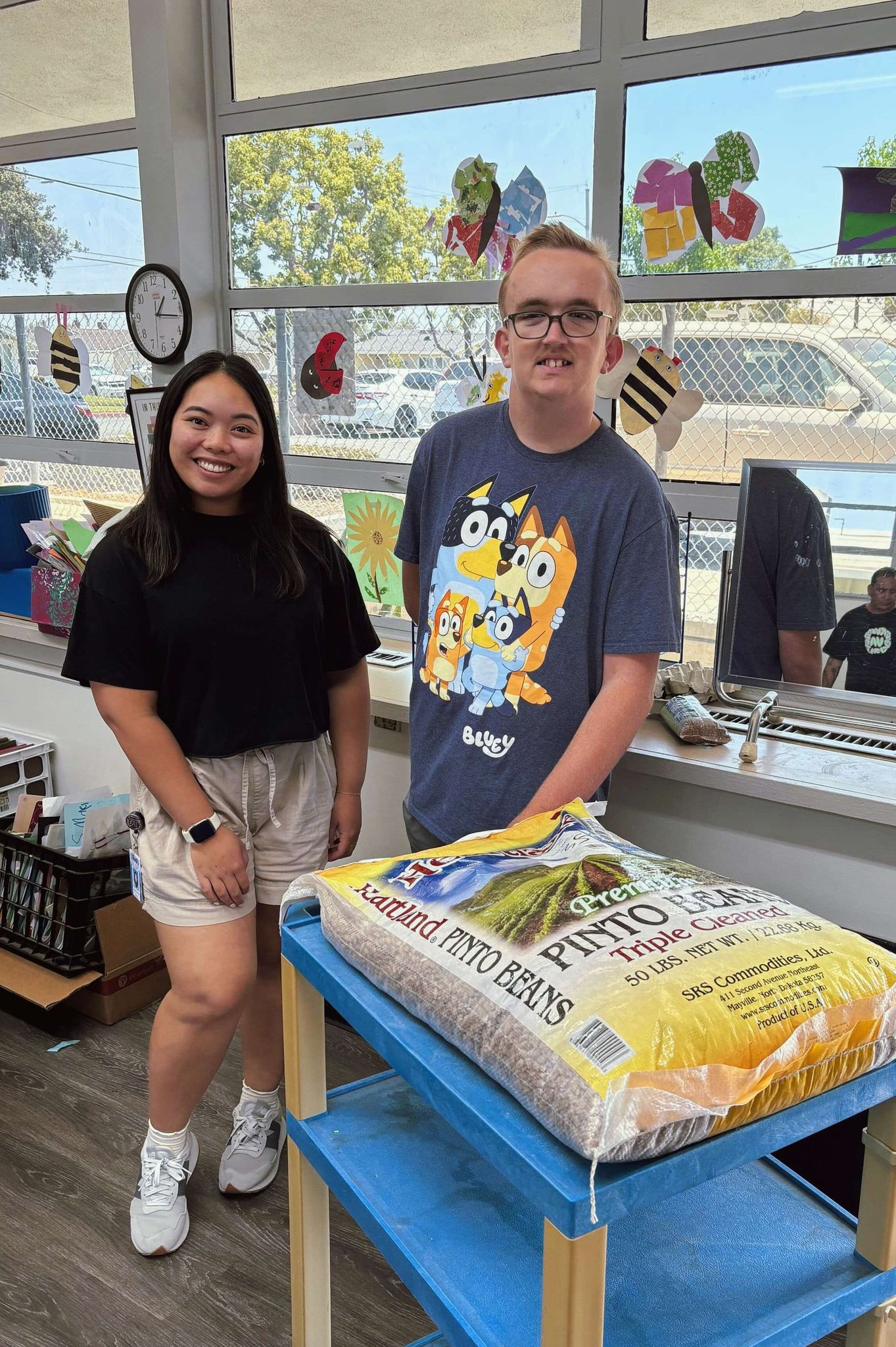 Teacher and student with a bag of pinto beans for sensory bins.